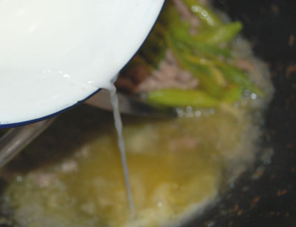 把火关小一点，用锅铲把肉丝和黄花菜推向一边，把加了味精的水淀粉倒入中间的汁水中.jpg
