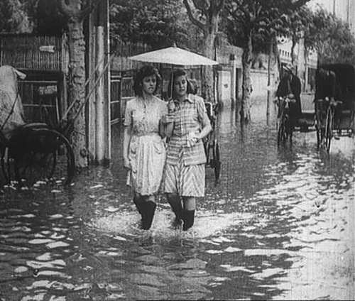 1948年暴雨后的霞飞路，2个外国女郎不紧不慢悠闲走着.jpg